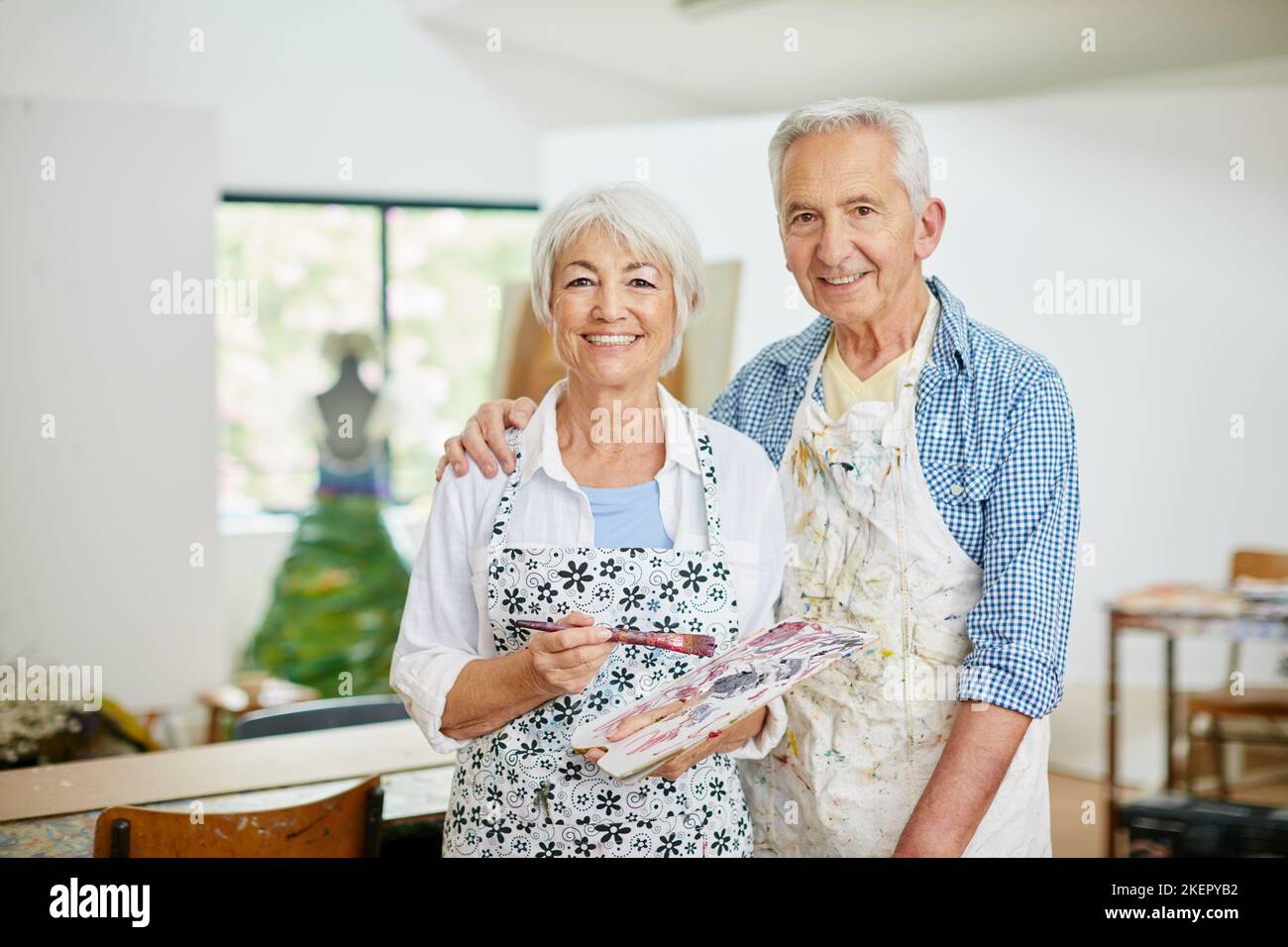 Aus Liebe zur Kreativität. Ein Seniorenpaar malt zu Hause. Stockfoto
