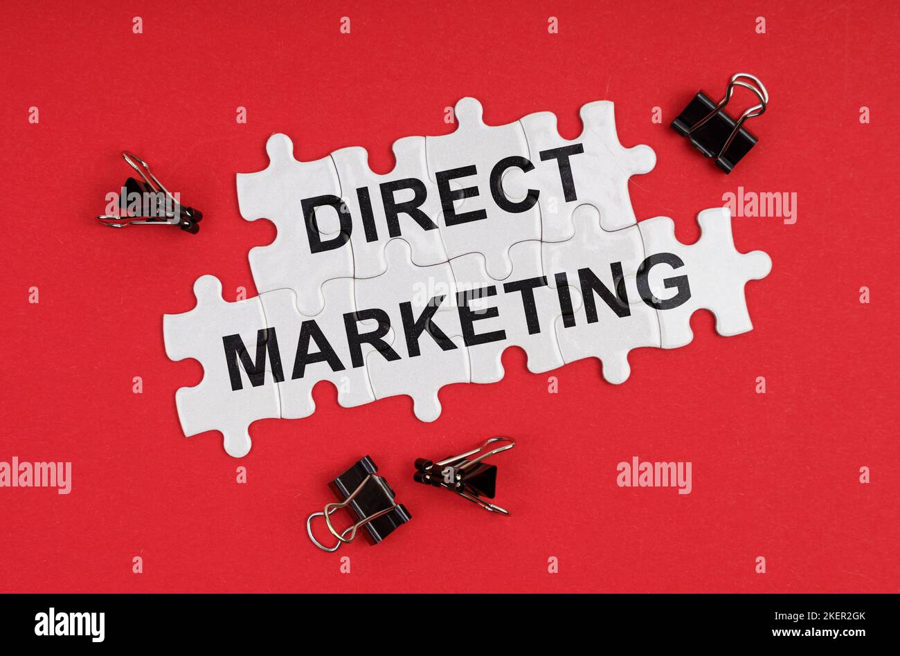 Wirtschaft und Handel. Auf einem roten Hintergrund gibt es Rätsel mit der Aufschrift - Direct Marketing Stockfoto