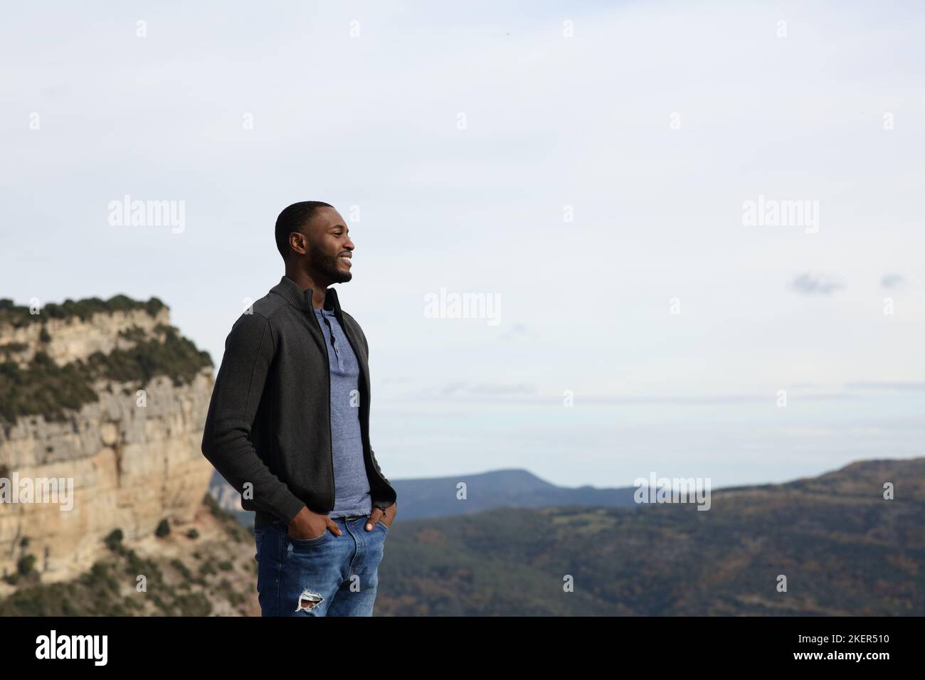 Glücklicher schwarzer Mann, der die Natur im Berg betrachtet Stockfoto