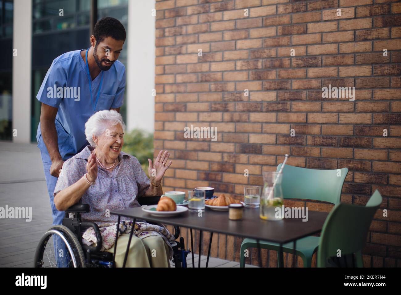 Pfleger beim Frühstück mit seinem Kunden im Café. Stockfoto