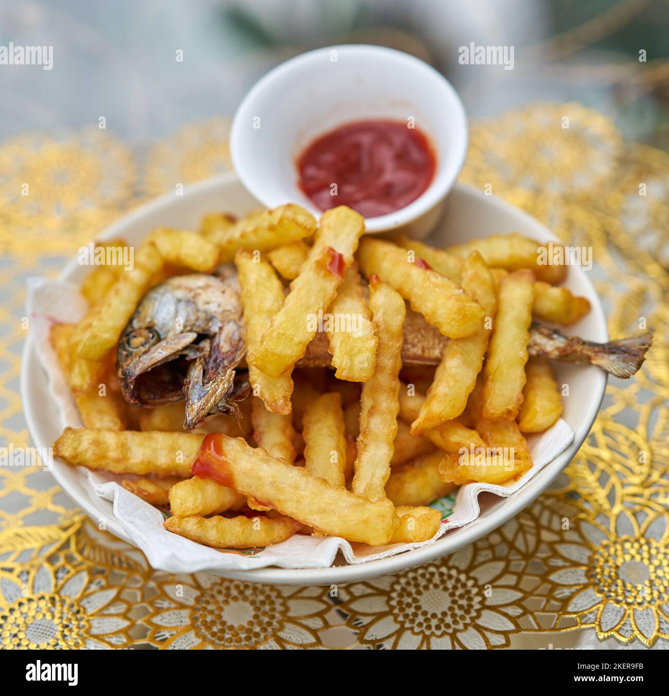 Ein Teller mit Fisch und Chips mit Tomatenketchup. Stockfoto