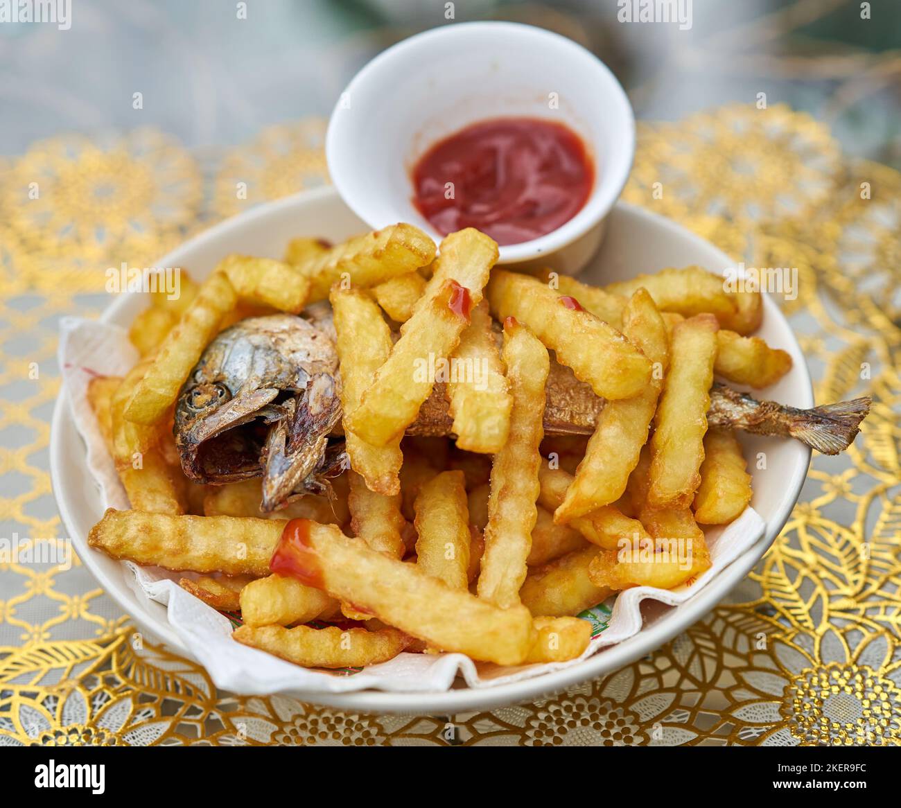 Ein Teller mit Fisch und Chips mit Tomatenketchup. Stockfoto