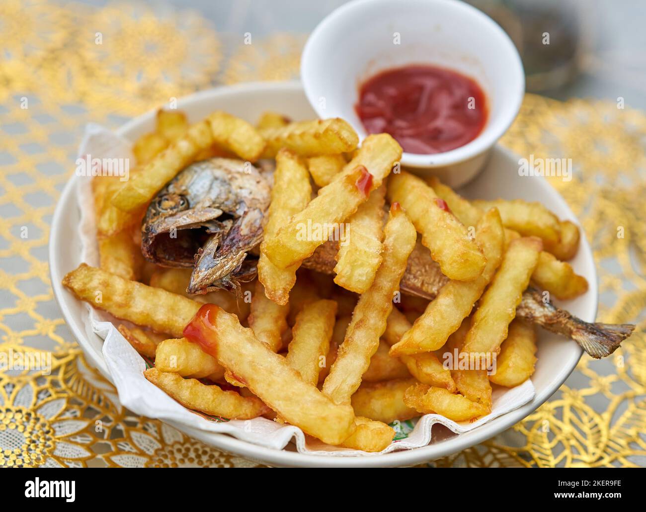 Ein Teller mit Fisch und Chips mit Tomatenketchup. Stockfoto