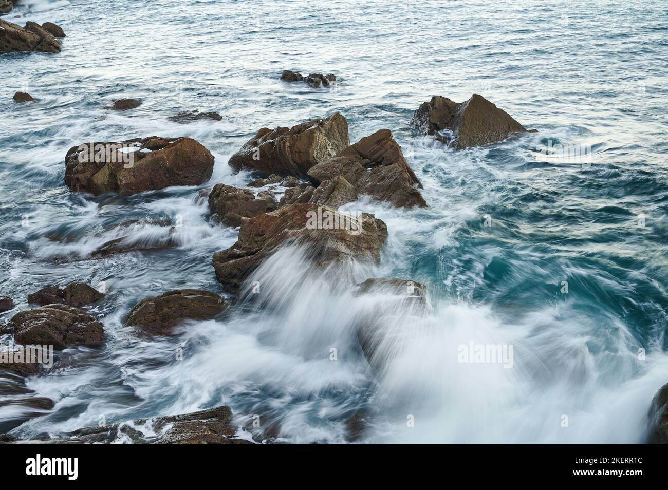 Wellen brechen auf den Felsen mit Langzeitbelichtung Bild Stockfoto