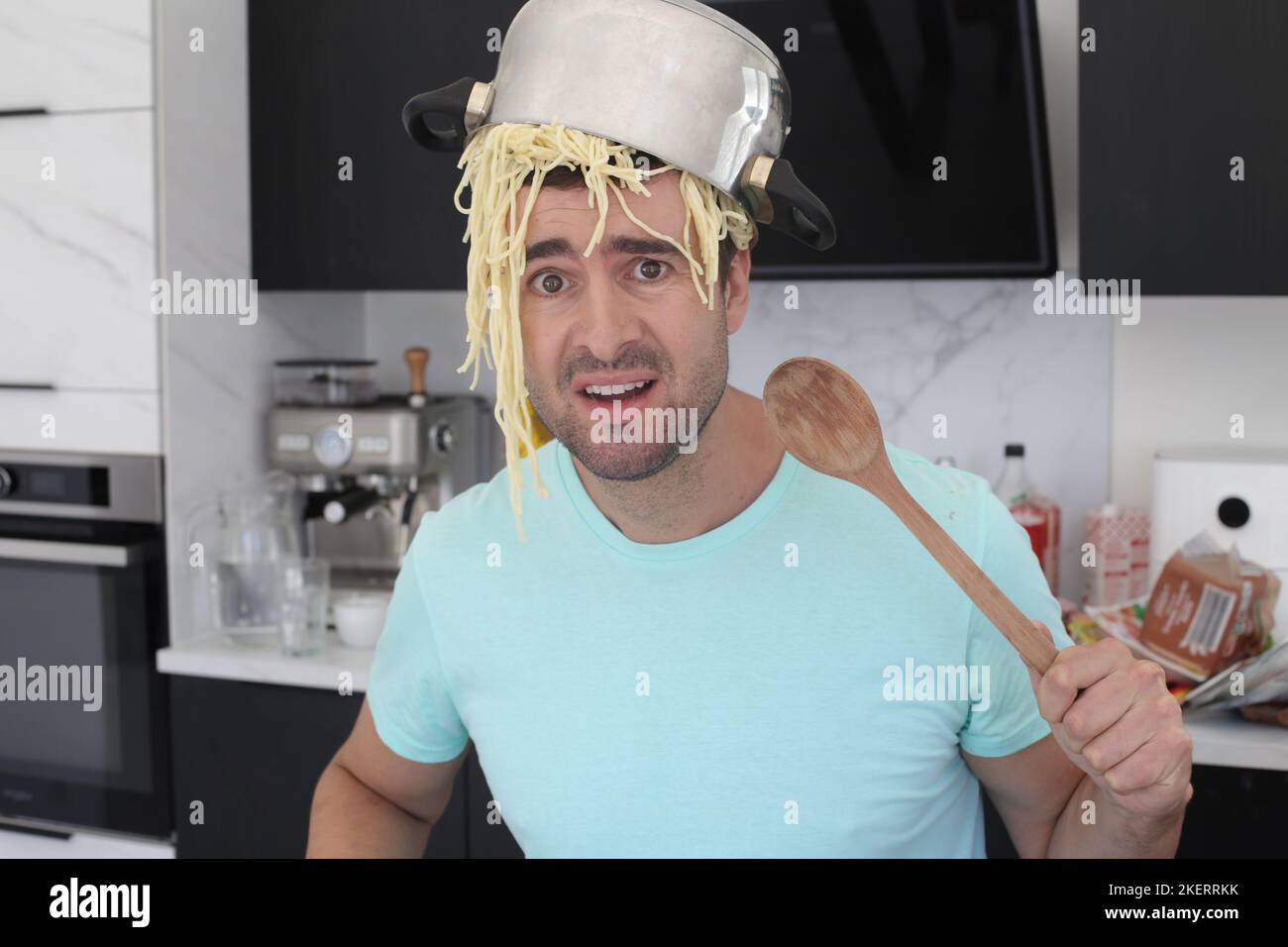 Chaotischer Koch versucht, Pasta zu machen Stockfoto