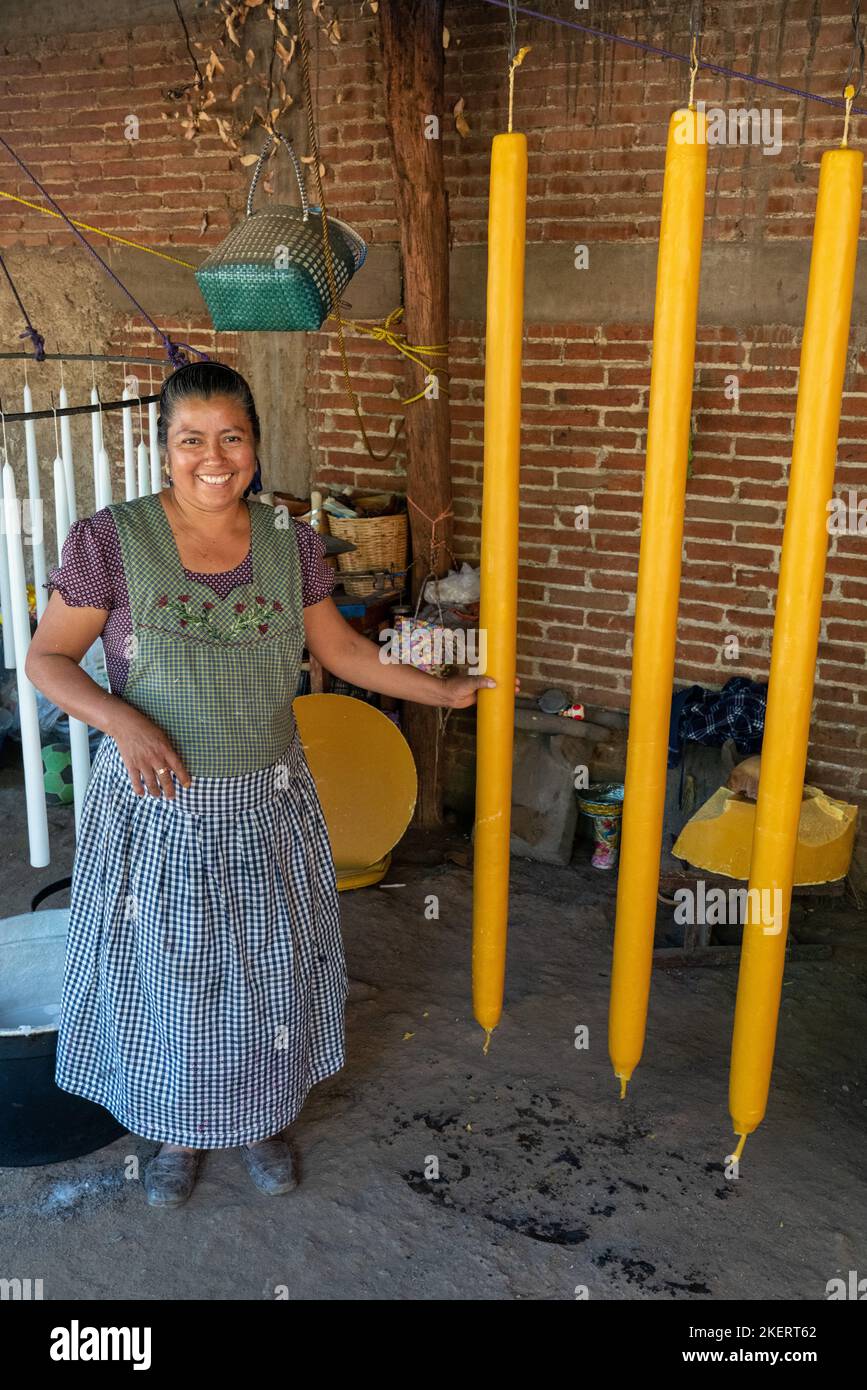 Ein Kerzenmacher zeigt große, konische Kerzen in einer Werkstatt in Teotitlan del Valle, Oacaca, Mexiko. Stockfoto