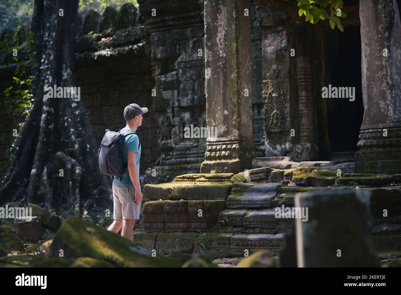 Mann mit Rucksack kommt zum alten Tempel. Reisende in Kambodscha. Stockfoto