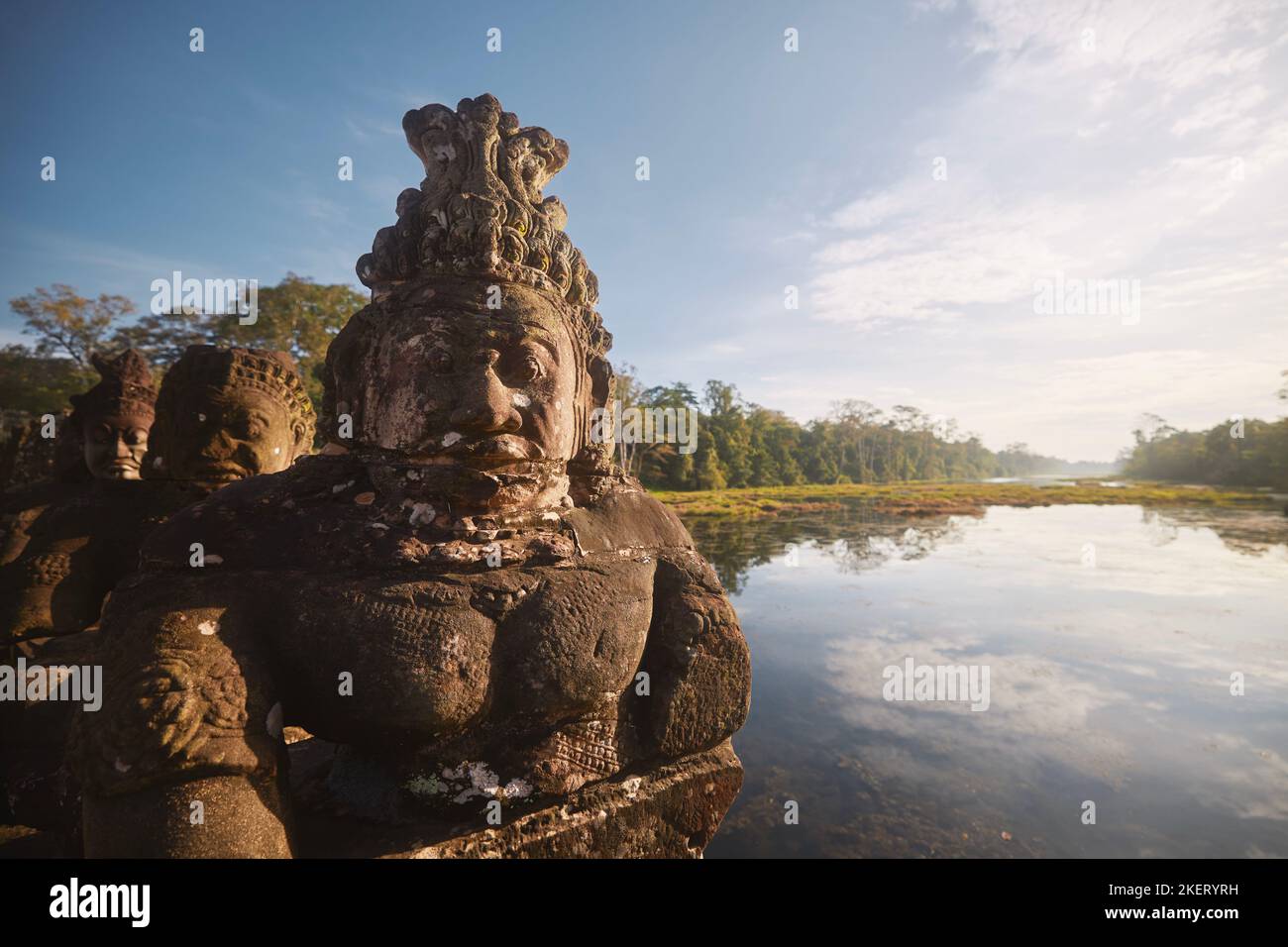 Gesichter von Statuen entlang der Straße zum Angkor Thom Tempel gegenüber der Landschaft. Berühmtes Reiseziel in der Nähe von Siem Reap in Kambodscha. Stockfoto