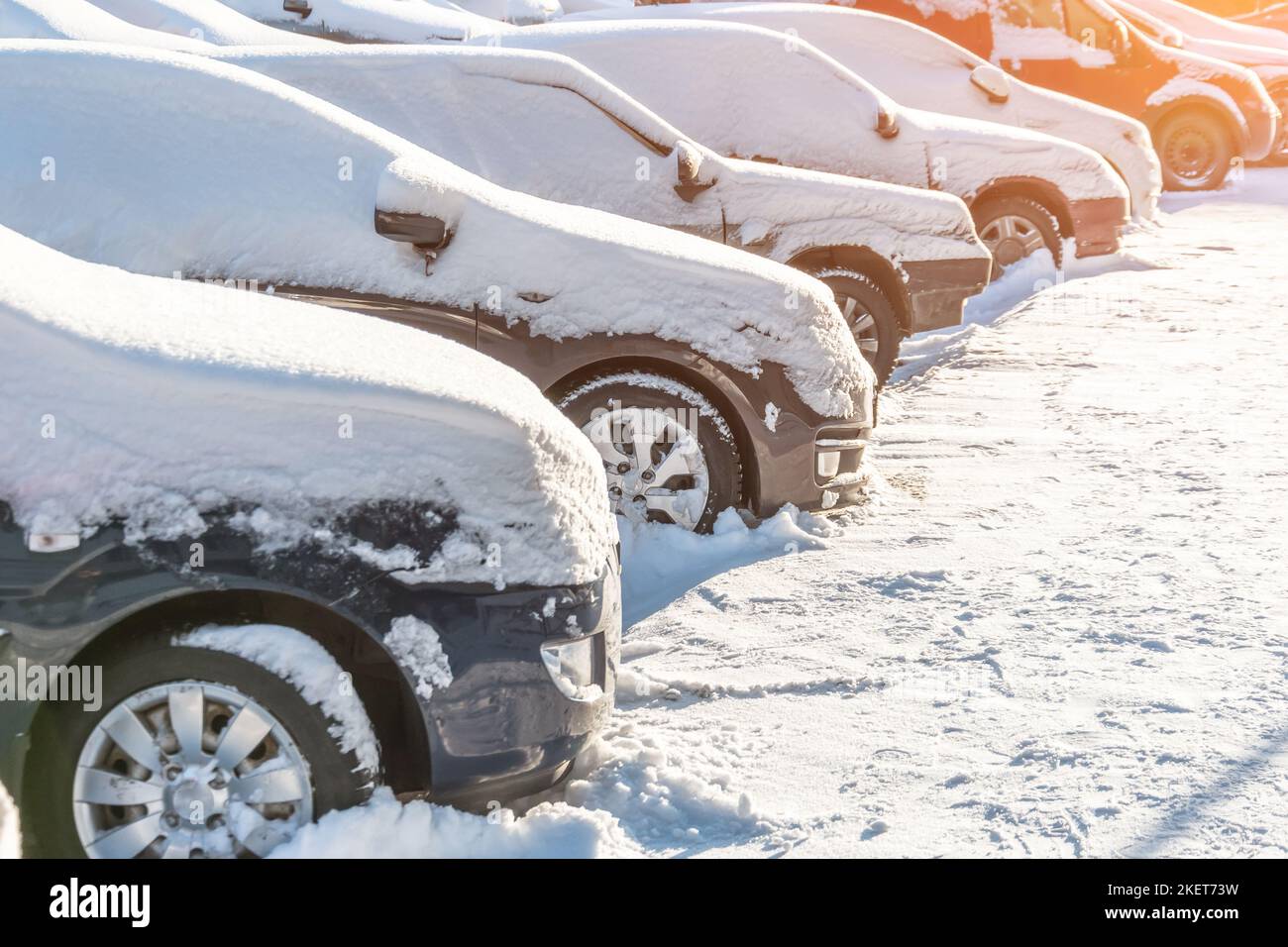 Autos mit Schnee bedeckt auf einem Parkplatz im Wohngebiet Stockfoto