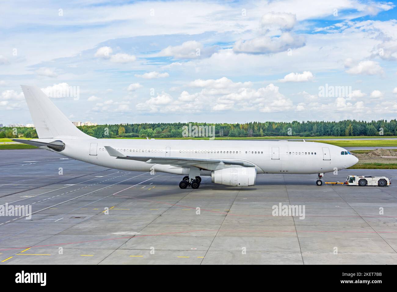 Weiß lackiertes Passagierflugzeug, das vom Parkplatz zurückgeschoben wurde Stockfoto