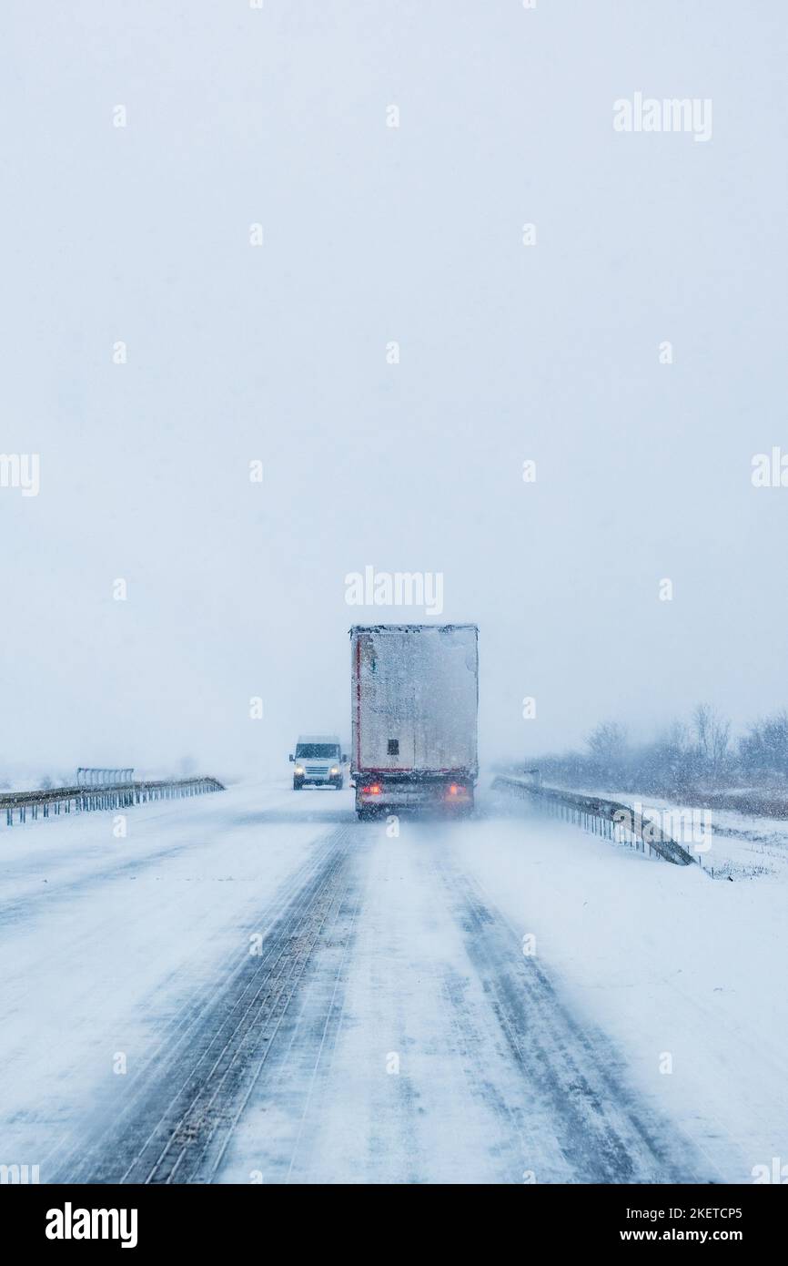 Gütertransport LKW auf der Straße im Schneesturm Schneesturm, schlechte Wetterbedingungen für Transport-Ereignis, selektive Fokus Stockfoto