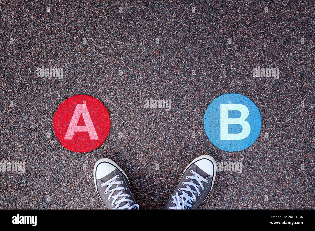 A oder B, zwei-Optionen-Konzept mit Sneakers auf Asphalt, Draufsicht Stockfoto
