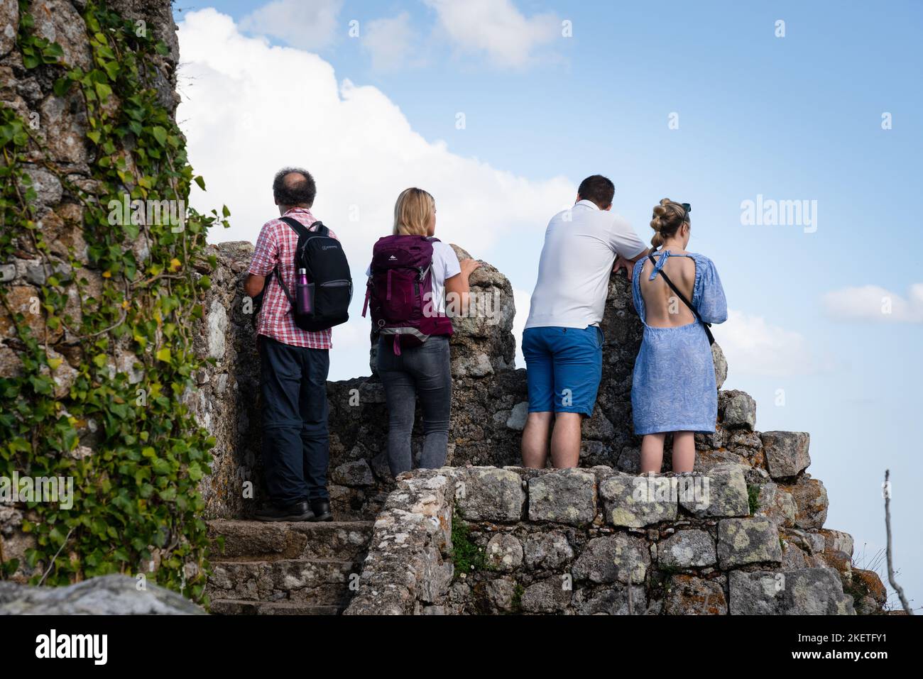 Touristen klettern auf die befestigten Mauern und Türme der maurischen Burg der Mauren aus dem 10.. Jahrhundert (Castelo dos Mouros) oberhalb von Sintra, Portugal. Stockfoto