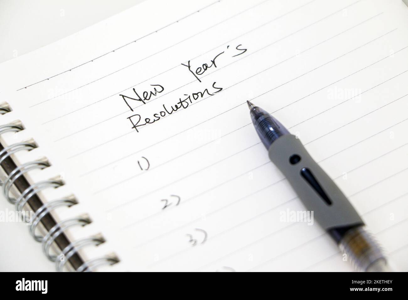 Neujahrsvorsätze schreiben, Liste auf weißem Notizblock mit Kugelschreiber. Ziele für das neue Jahr setzen. Stockfoto