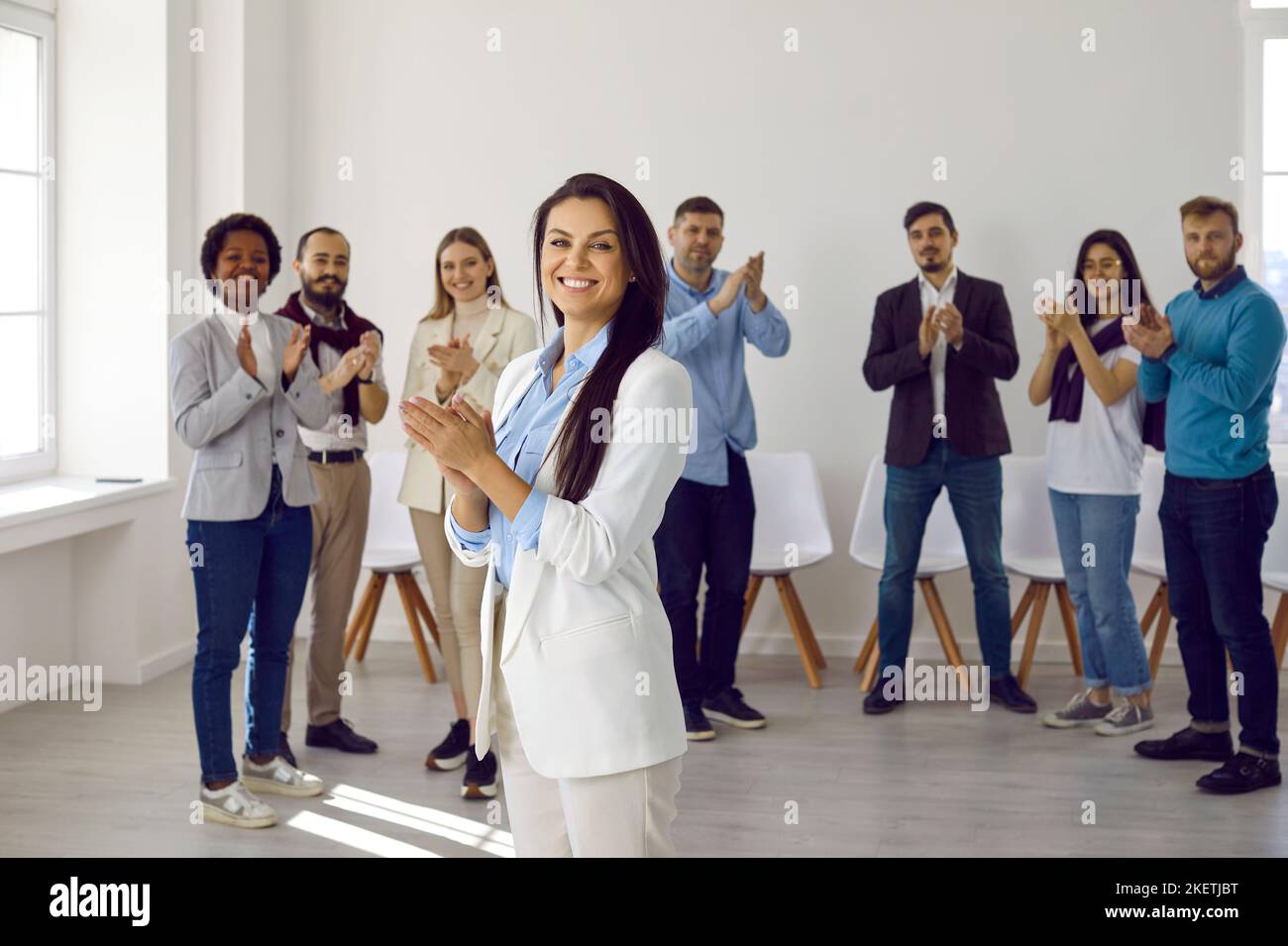 Glückliche, erfolgreiche multirassische Geschäftsteams applaudieren, lachen und jubeln ihren Erfolg an, um ihrem Chef im modernen Büroumfeld zu gratulieren. Stockfoto
