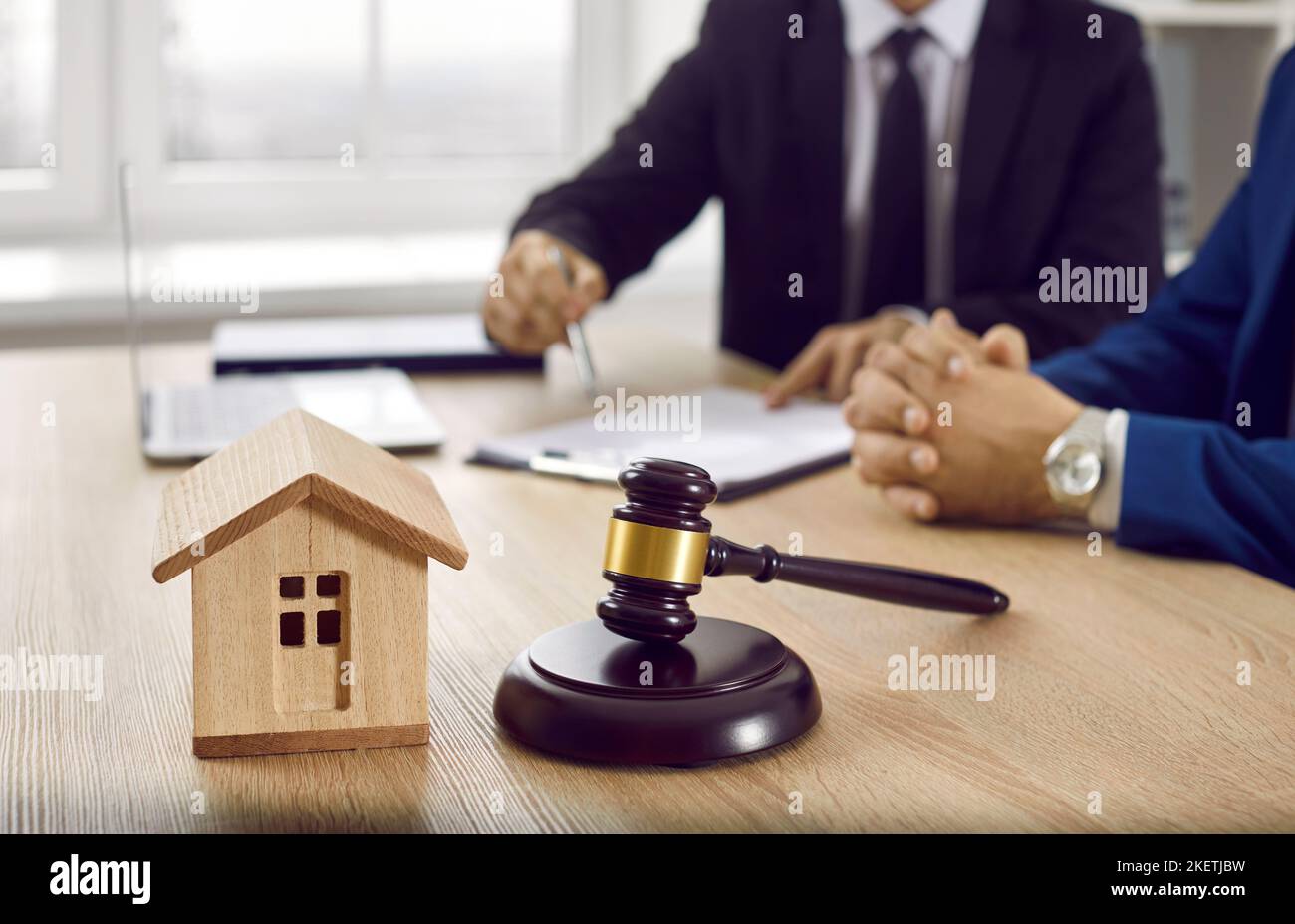 Hausmodell und Rechtsanwalt auf Tisch im Anwaltsbüro Stockfoto