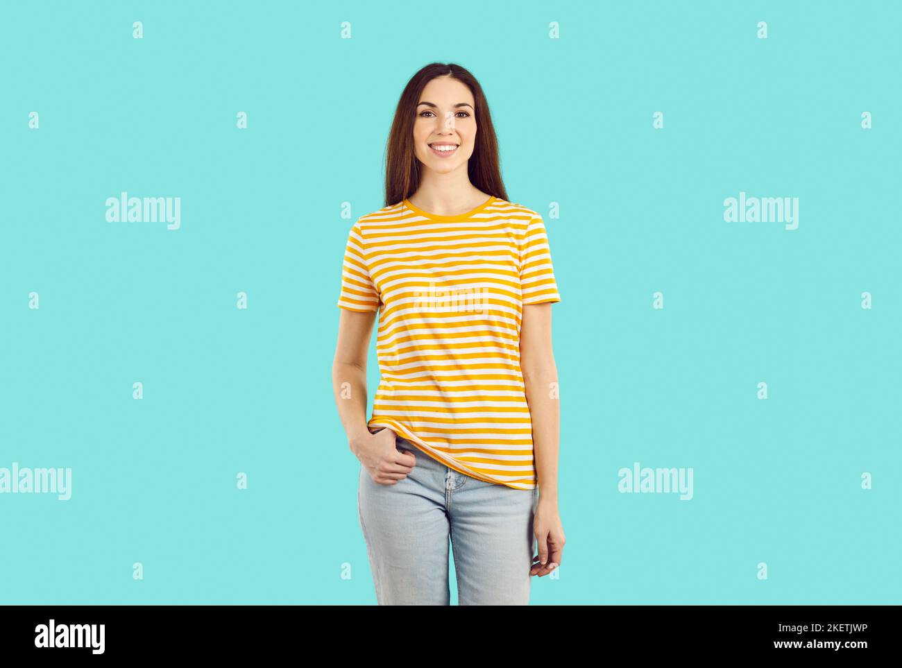 Studio-Porträt einer schönen lächelnden jungen Frau in legerer Kleidung auf hellblauem Hintergrund. Stockfoto