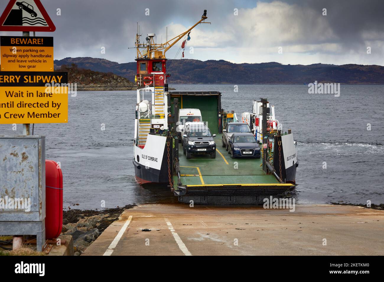 An einem bewölkten Märznachmittag nähert sich die Fähre der Isle of Cumbrae von Portavadie der Fährenrutsche in Tarbert. Argyll und Bute. Schottland Stockfoto