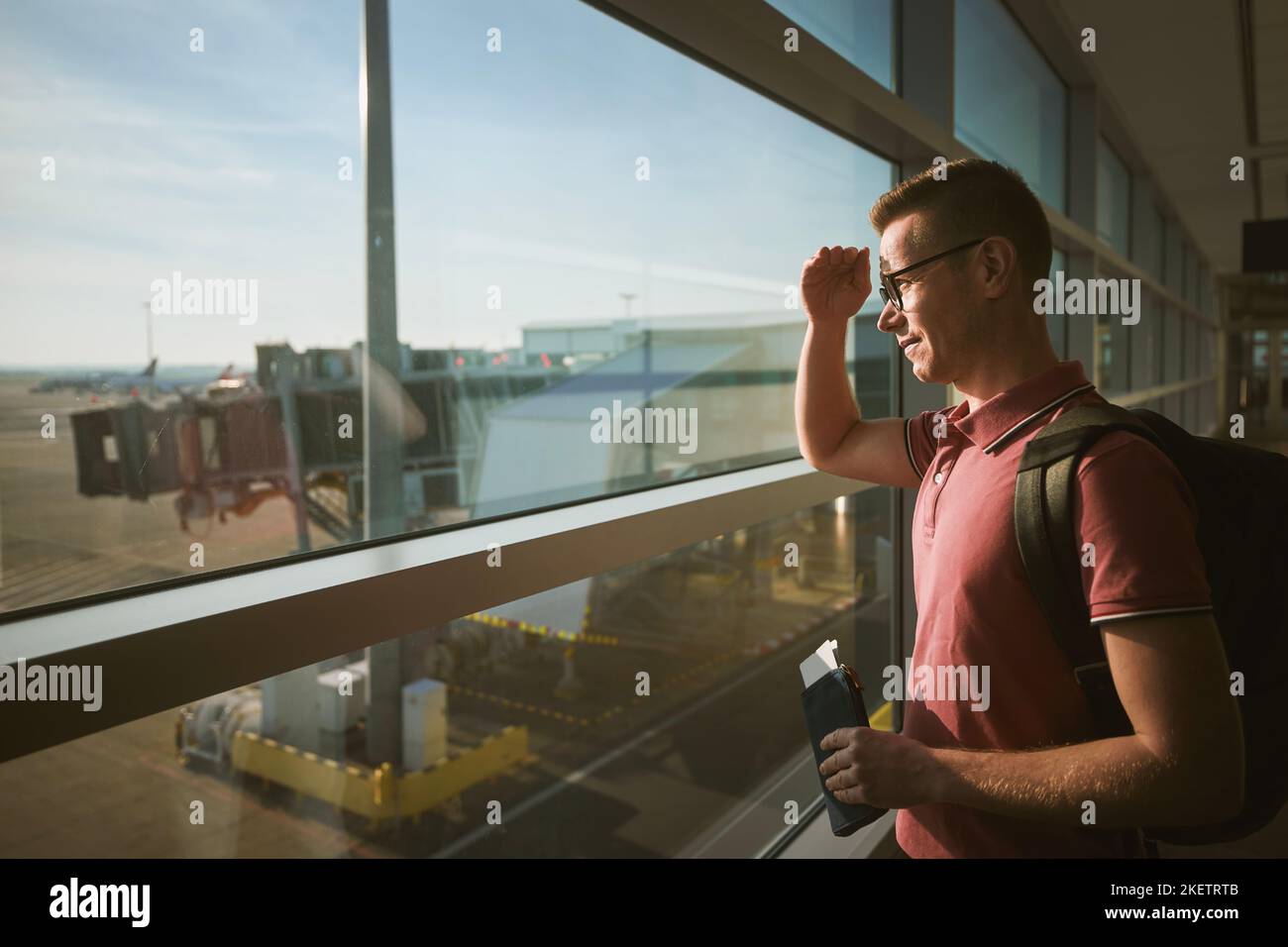 Mann reist mit dem Flugzeug. Passagier mit Bordkarte während der Wartezeit am Flughafen. Stockfoto