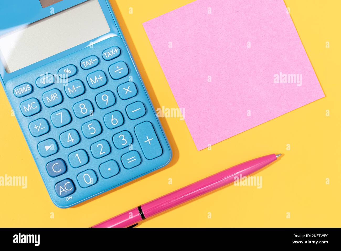 Flaches Lay von Rechner, Stift und leerer Haftnotiz auf gelbem Hintergrund. Lebendige Farben Mock up Stockfoto