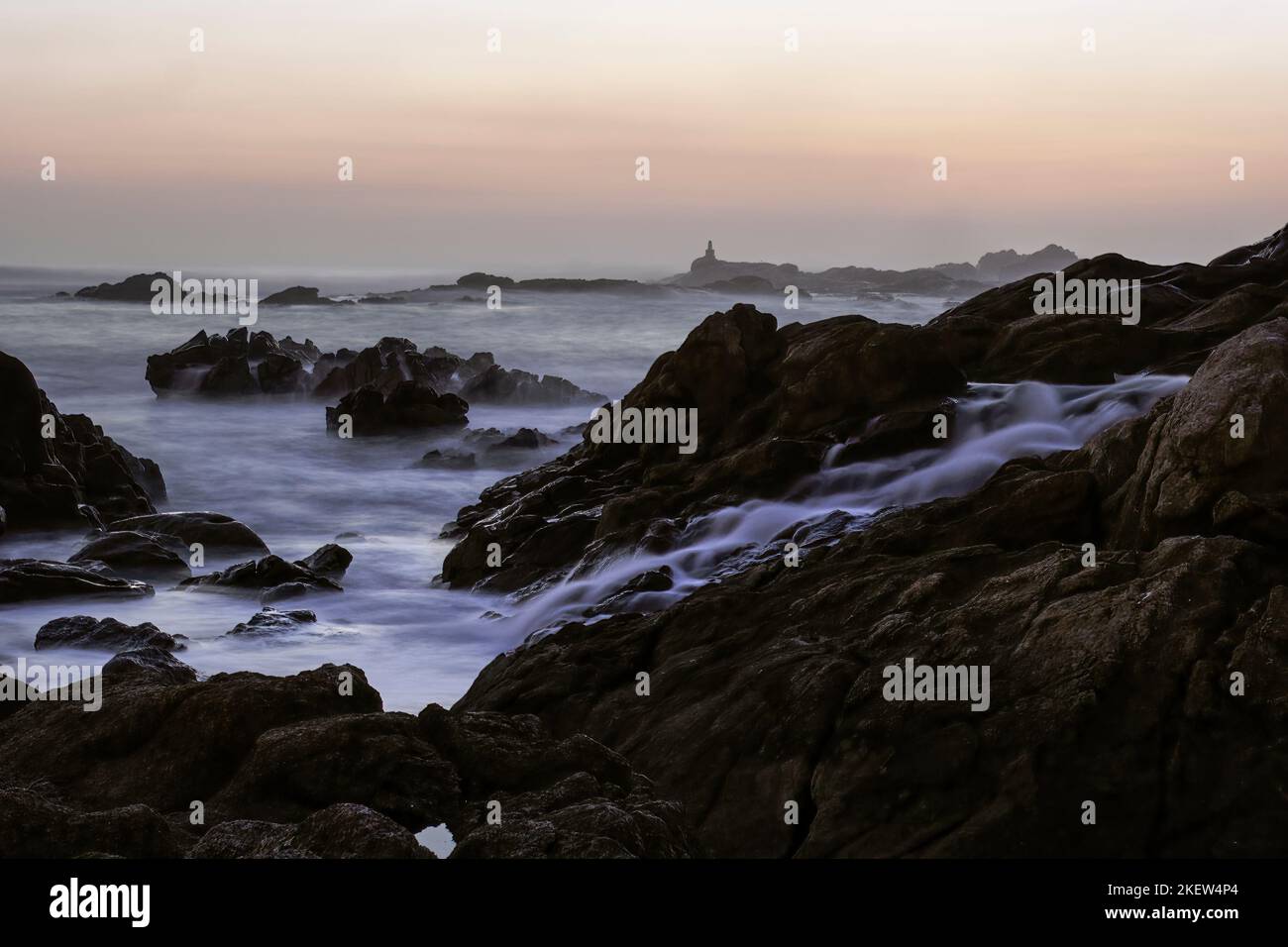 Nördlicher portugiesischer felsiger Strand bei Sonnenuntergang oder Dämmerung. Langzeitbelichtung. Stockfoto