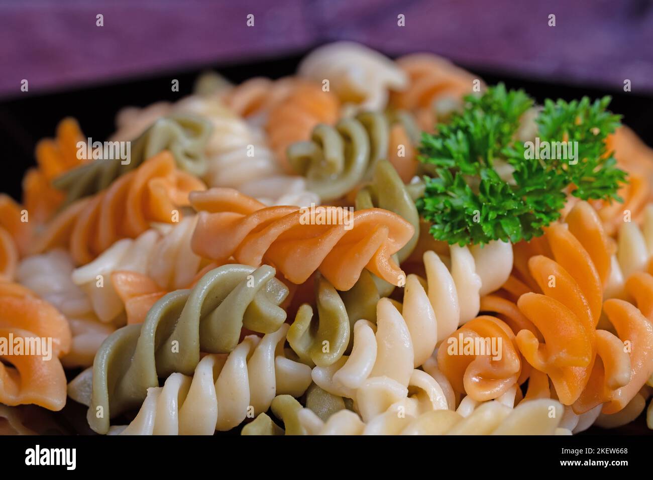 Bunte Spiralnudeln auf einem Teller Stockfoto