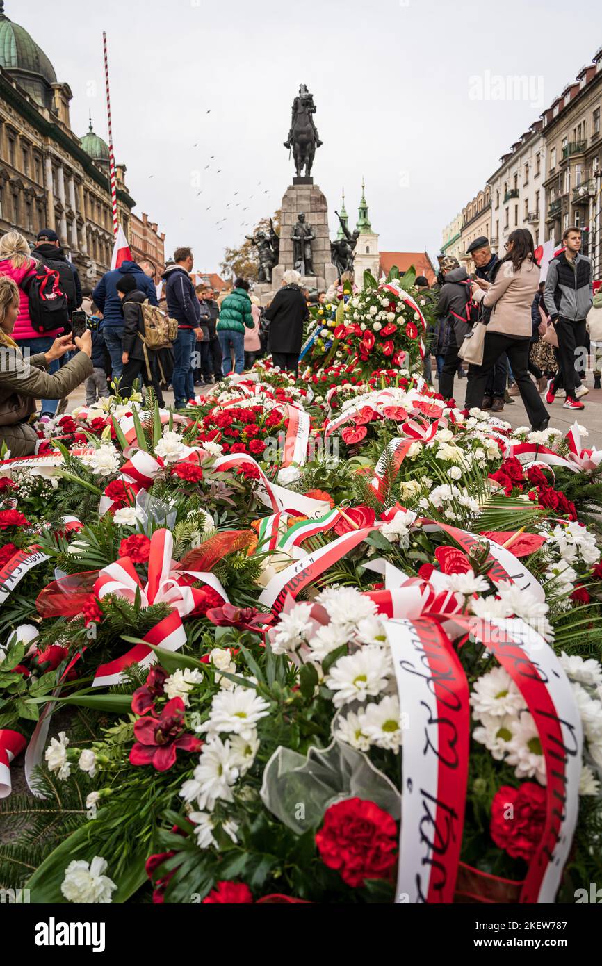 Polen Unabhängigkeitstag in Krakau. Menschen, die Blumen mit polnischen Flaggen neben dem Denkmal von Grunwald am Plac Matejki hinterlassen. Krakau, Polen - 11. November 2022. Stockfoto