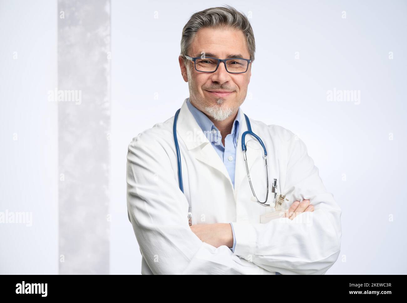 Arzt mittleren Alters in Laborkittel. Freundlicher Arzt, Hausarzt. Mittlerer Erwachsener, Mann im reifen Alter, glücklich lächelnd. Porträt isoliert auf Weiß. Stockfoto