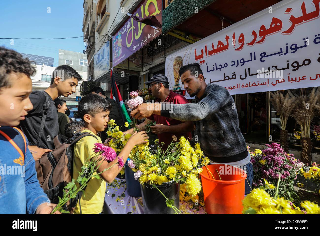 In einem Blumengeschäft verteilen Palästinenser Blumen an Passanten, um am 14. November 2022 die Weltmeisterschaft 2022 in Katar im Gazastreifen zu feiern. Stockfoto