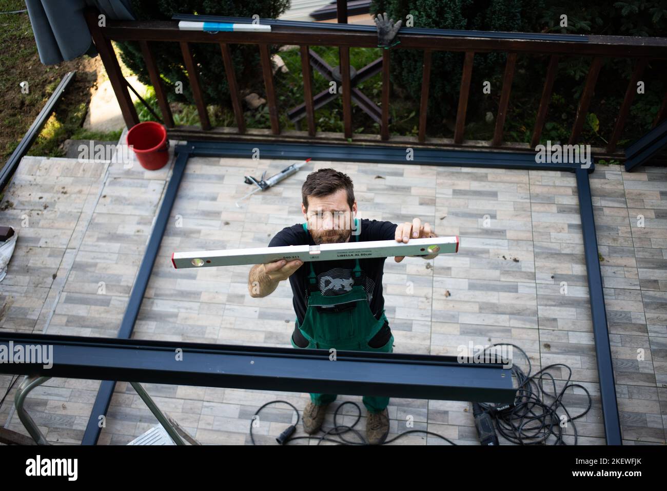 Bauarbeiter, der ein Terrassendach auf dem Haus installiert Stockfoto