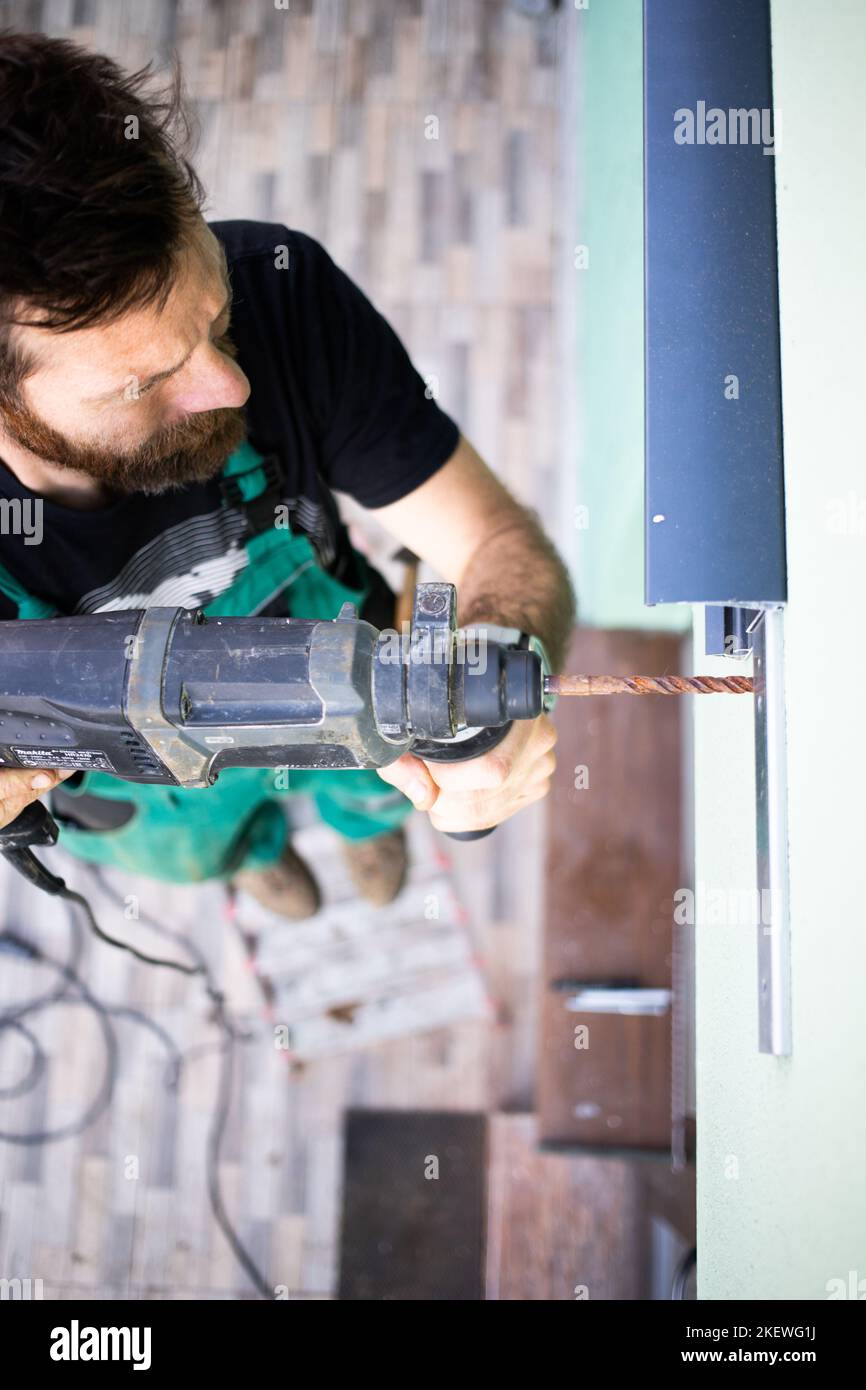Bauarbeiter, der ein Terrassendach auf dem Haus installiert Stockfoto