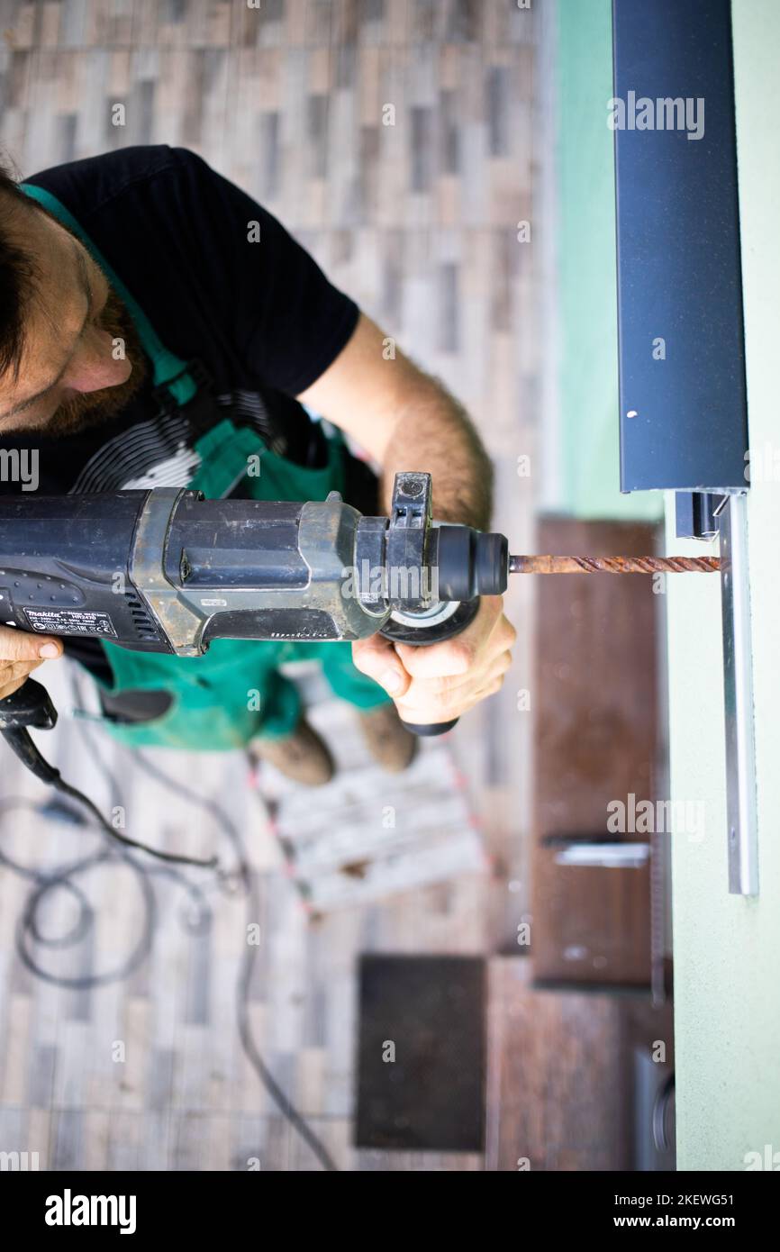 Bauarbeiter, der ein Terrassendach auf dem Haus installiert Stockfoto