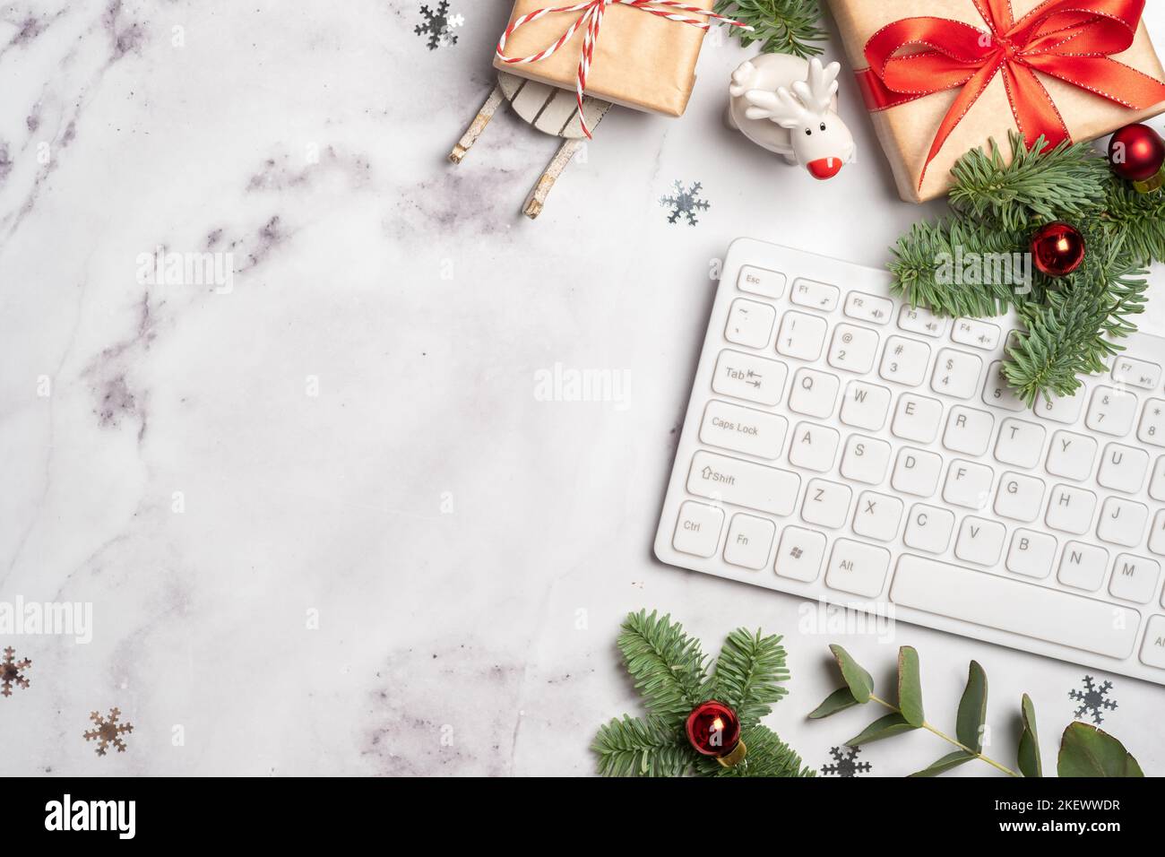 Büroarbeitsplatte zu Weihnachten und Neujahr mit Tastatur, Geschenkbox und weihnachtsbaum, Flatlay-Ansicht von oben mit Kopierfläche. Stockfoto
