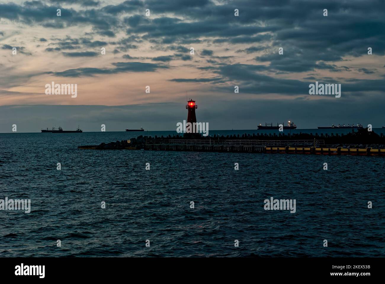 Leuchtturm im Hintergrund des Abendmeers. Eine Postkarte aus dem Meer mit einem Leuchtturm. Stockfoto