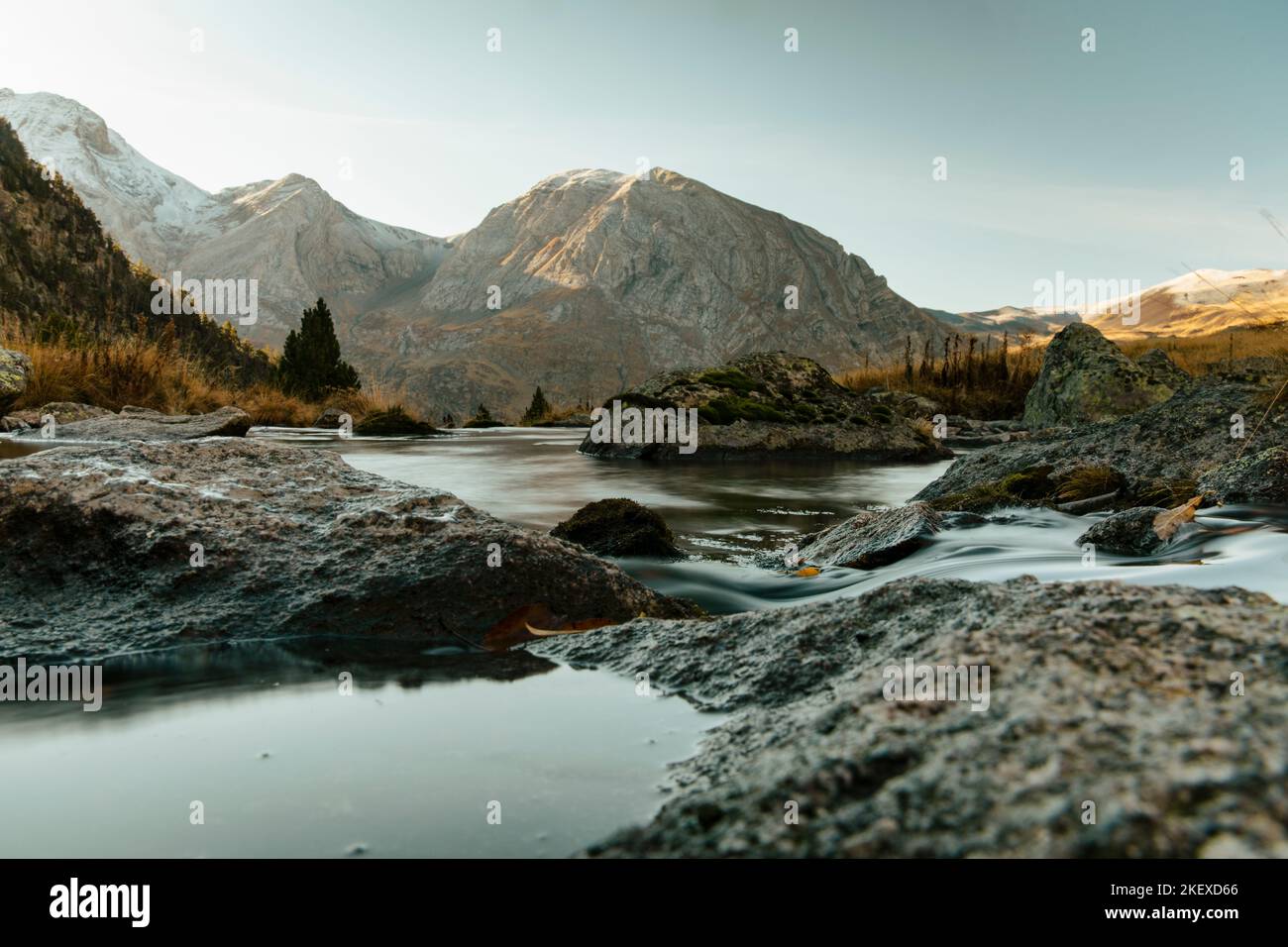 Fluss überquert ein Tal mit einem Berg im Hintergrund Stockfoto