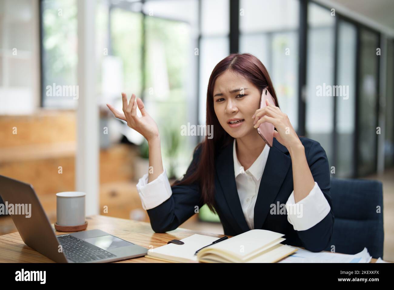 Geschäftsfrau, die beim Telefonieren einen ernsthaften Ausdruck zeigt Stockfoto