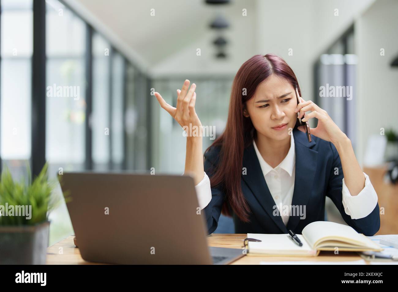 Geschäftsfrau, die beim Telefonieren einen ernsthaften Ausdruck zeigt Stockfoto