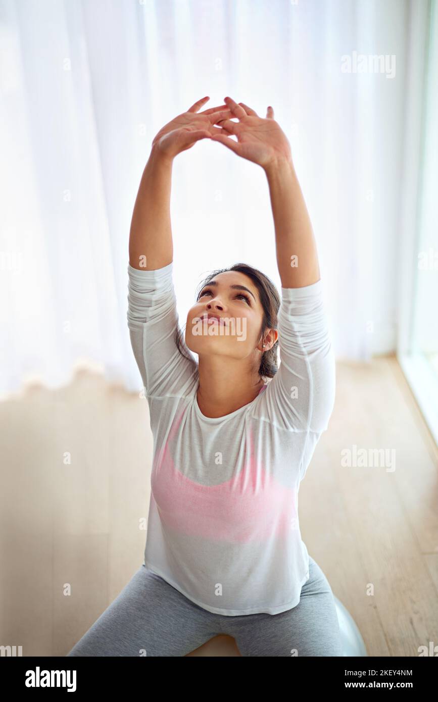 Stretching verhindert Verletzungen und weniger Muskelkater. Eine junge Frau, die Yoga macht, dehnt sich aus. Stockfoto