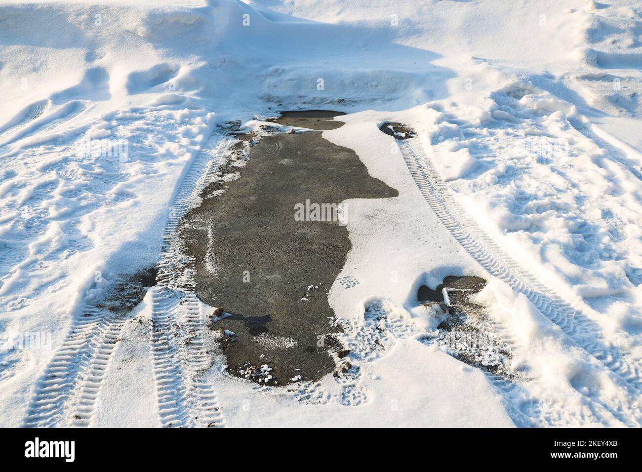 Ein leerer Parkplatz ohne Schnee, auf dem vor kurzem ein Auto geparkt wurde. Saisonabhängig Stockfoto