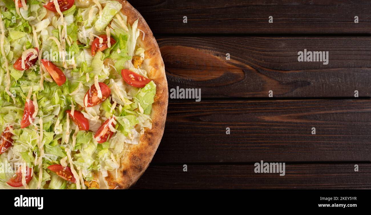 Köstliche Pizza Caesar mit weißem Huhn, Sauce, Parmesan, Kirschtomaten und frischem Salat auf Holzhintergrund. Restaurant Pizzeria Menü. Banner. Stockfoto