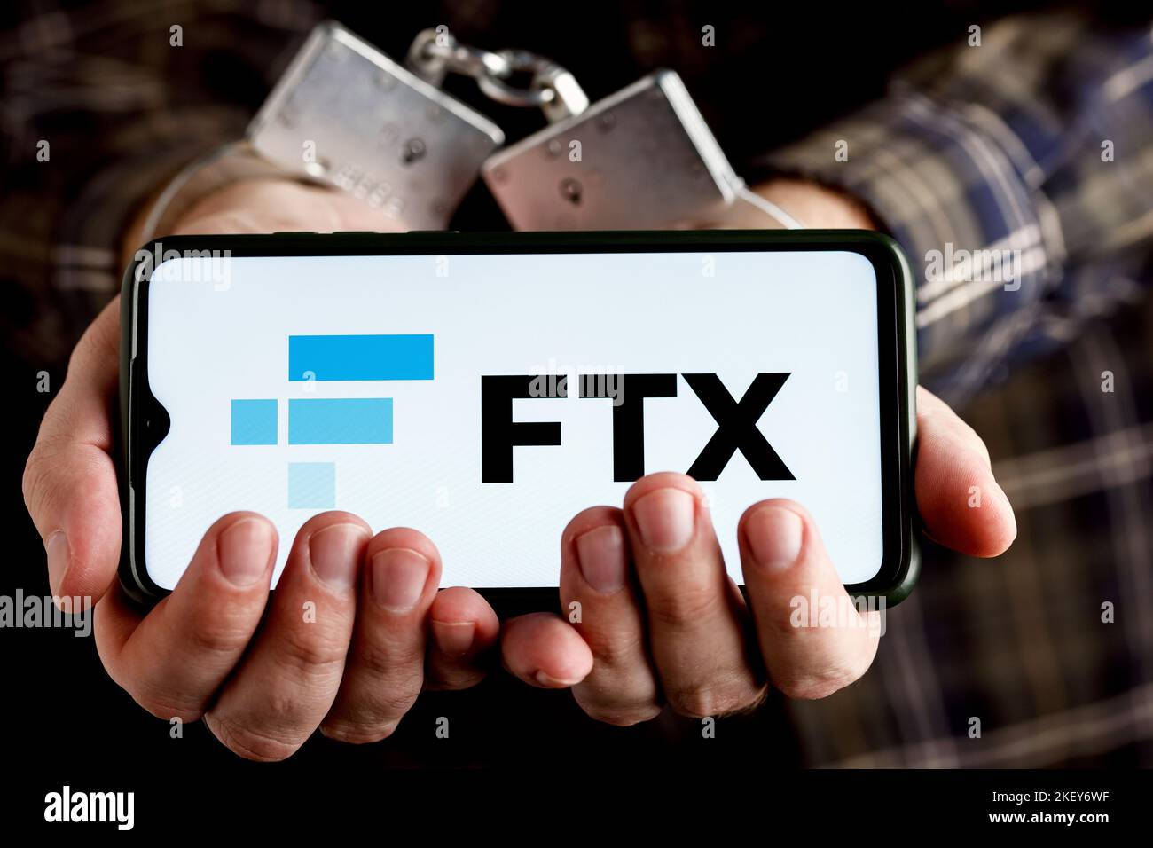 FTX ist eine Kryptowährungsbörse. Hände mit Handschellen halten das Smartphone mit FTX-Logo auf dem Bildschirm. Stockfoto