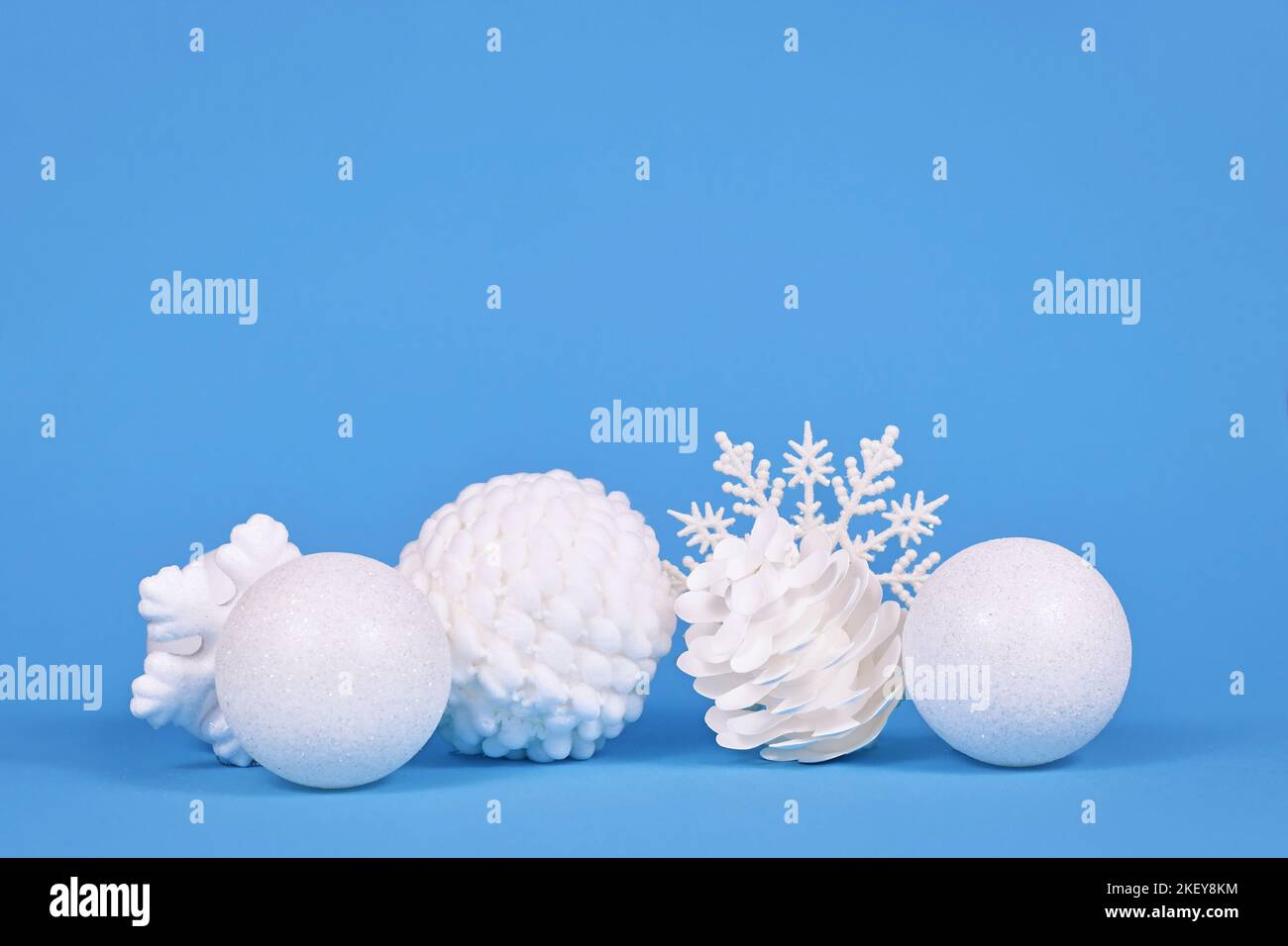 Weiße Weihnachtsbaum-Ornamente auf blauem Hintergrund mit Kopierraum Stockfoto
