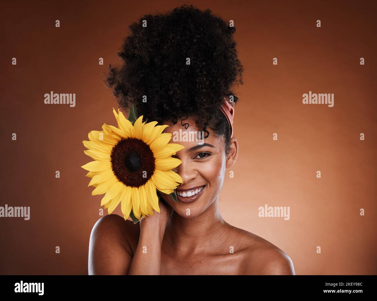 Schönheit, Hautpflege und Porträt von Modell mit Sonnenblume für Gesundheit, Wellness oder Körperpflege Antioxidantien. Gesichtskosmetik, natürliches Make-up und Gesicht Stockfoto