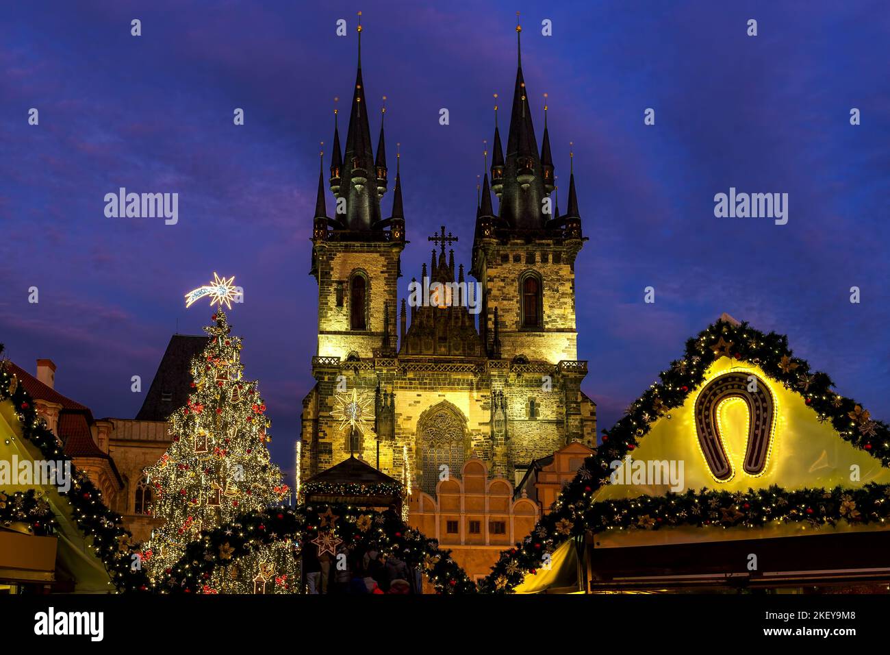 Beleuchteter Weihnachtsbaum und berühmte Tyn-Kirche auf dem Altstädter Ring unter dem Abendhimmel in Prag, Tschechische Republik. Stockfoto