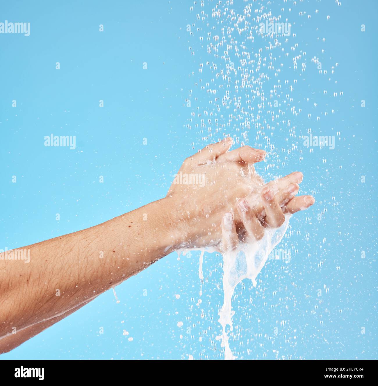 Hände putzen, Wasser spritzen und waschen für Hygiene-, Gesundheits- und Wellness-Mockup auf blauem Studiohintergrund. Hautfeuchtigkeit, feuchtigkeitsspendende Hautpflege Stockfoto