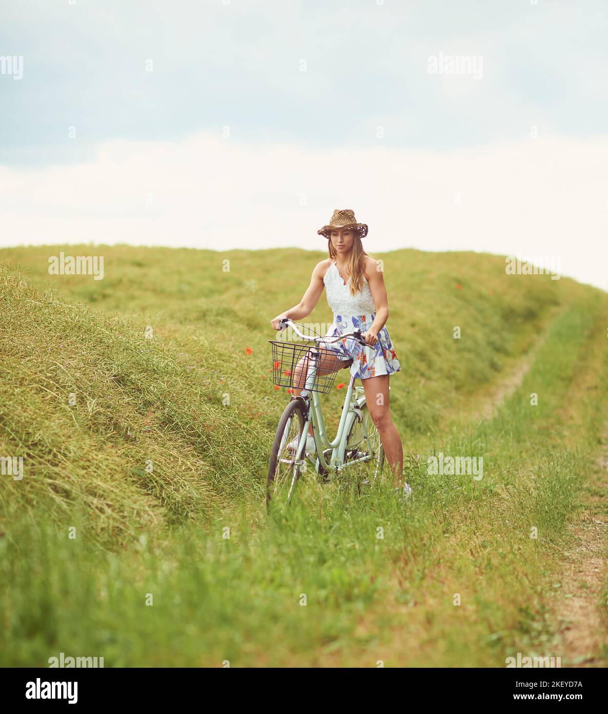 Im Zweifelsfall paddeln Sie es aus. Eine junge Frau, die durch die Landschaft radelt. Stockfoto