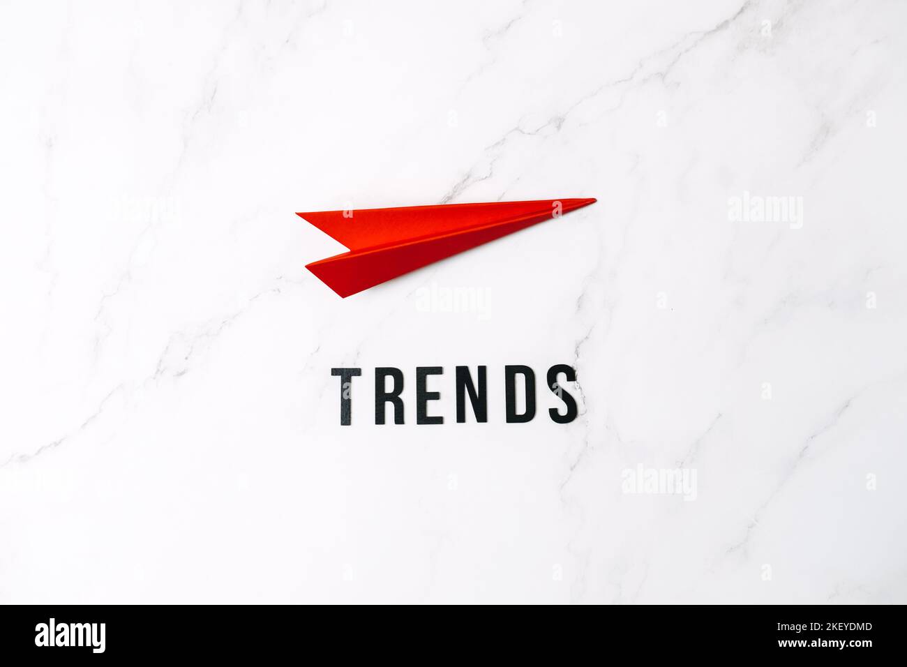 Globale Welttrends, Top New Trends, Forecasting. Worttrends und rote Papierebene auf rotem Hintergrund. Stockfoto