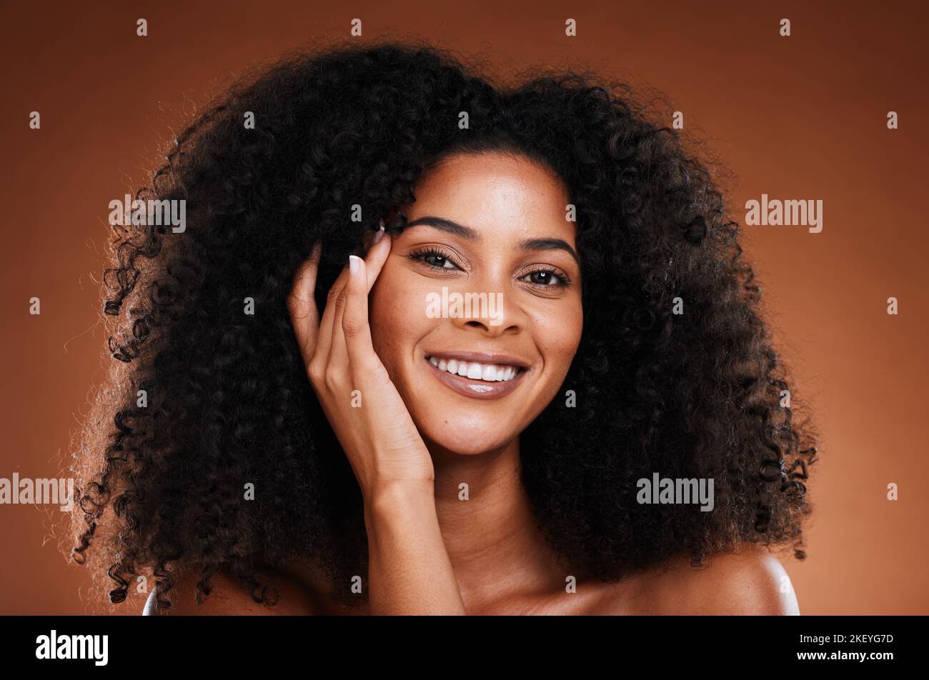 Wellness, Hautpflege und Haarpflege Porträt der schwarzen Frau mit glücklichen Gesicht berühren Textur. Gesundheit, Schönheit und natürliches afrikanisches Kosmetikmodell auf Braun Stockfoto