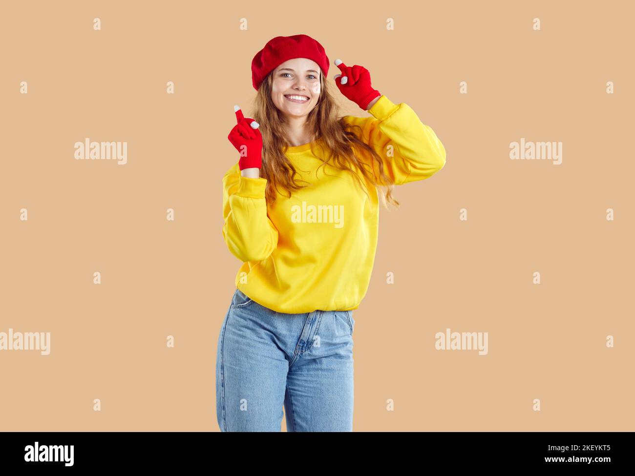 Nette junge Frau im Herbst Casual Kleidung hat Spaß auf hellbeigem Hintergrund im Studio. Stockfoto