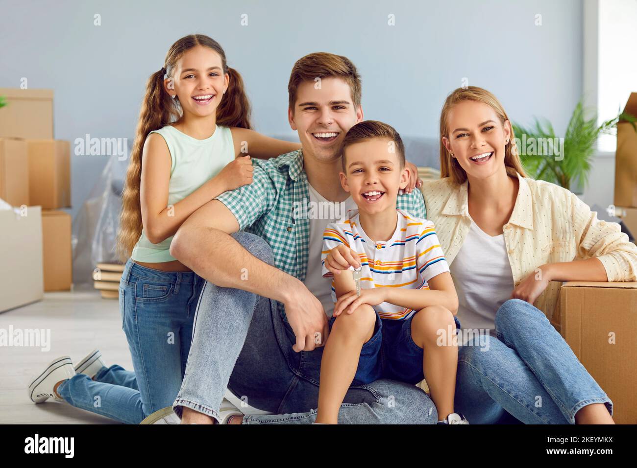 Porträt einer glücklichen jungen modernen Familie mit Kindern, die in ihr eigenes neues Haus ziehen. Stockfoto